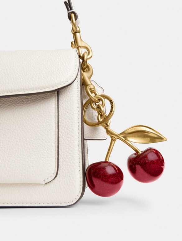 Bolso con el Cherry Bag Charm de Coach, con diseño de cerezas y estilo femenino