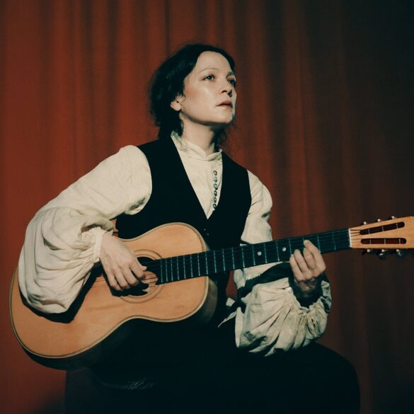 Natalia Lafourcade tocando su guitarra acústica en un escenario promocional Cancionera Tour 2025