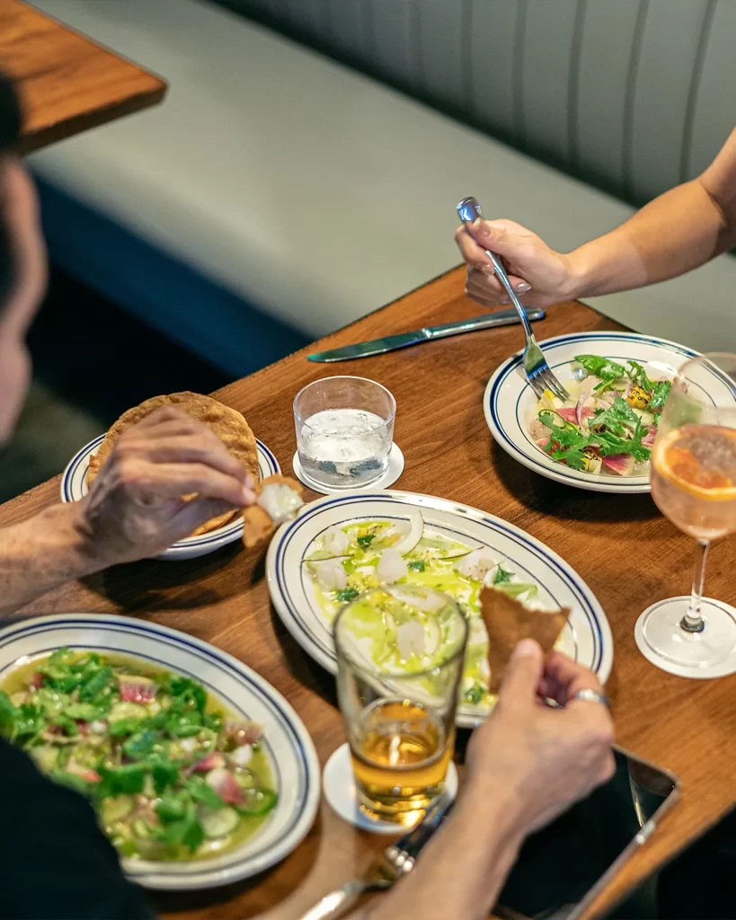 Platos estilo Baja Med servidos en mesa compartida en Monarca Baja Kitchen