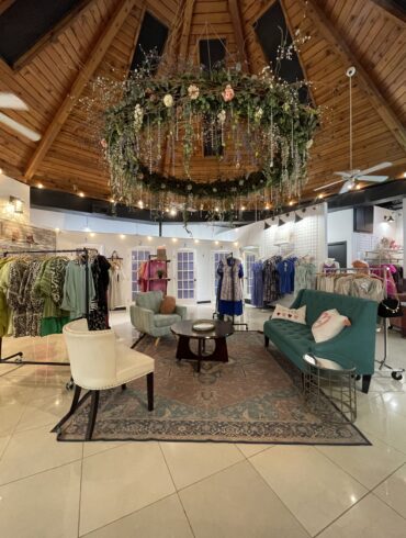 Interior de Shop 112 McAllen con ropa bohemia, accesorios y decoración floral acogedora