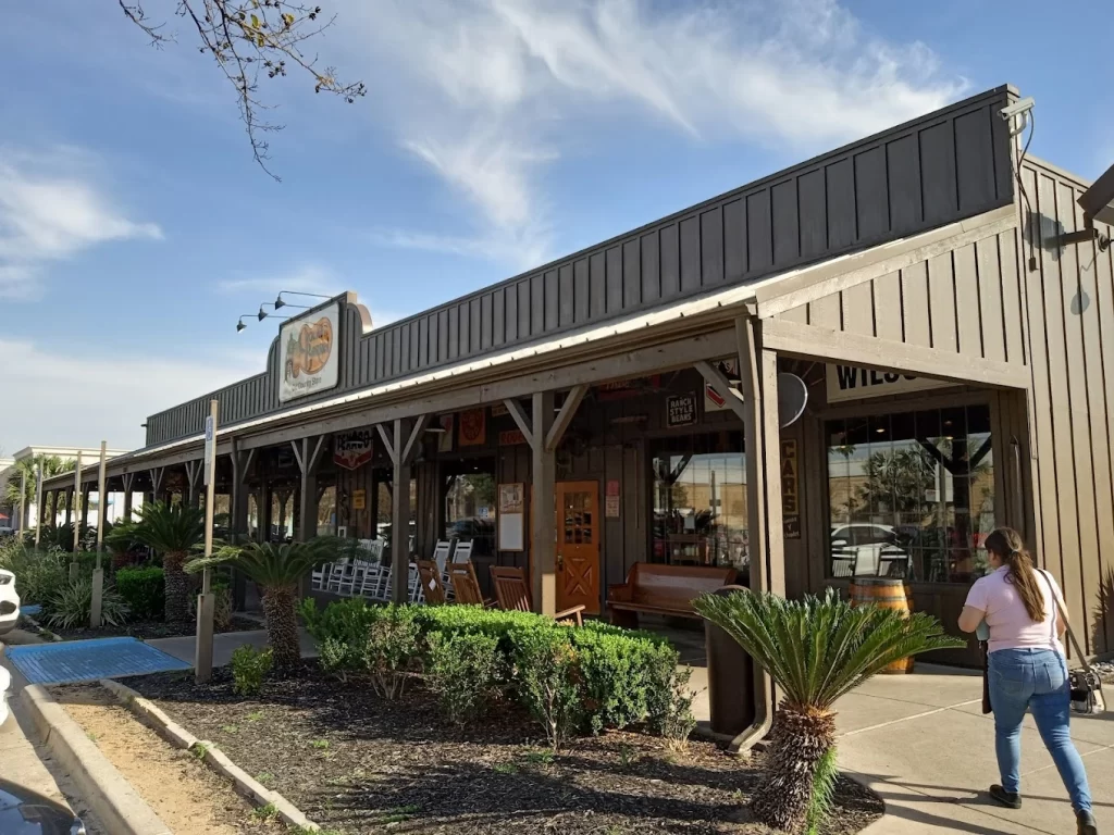 Fachada del restaurante Cracker Barrel con estilo rústico y bancas en la entrada.